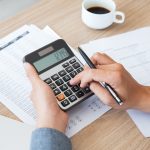Man using calculator to count income and outcome
